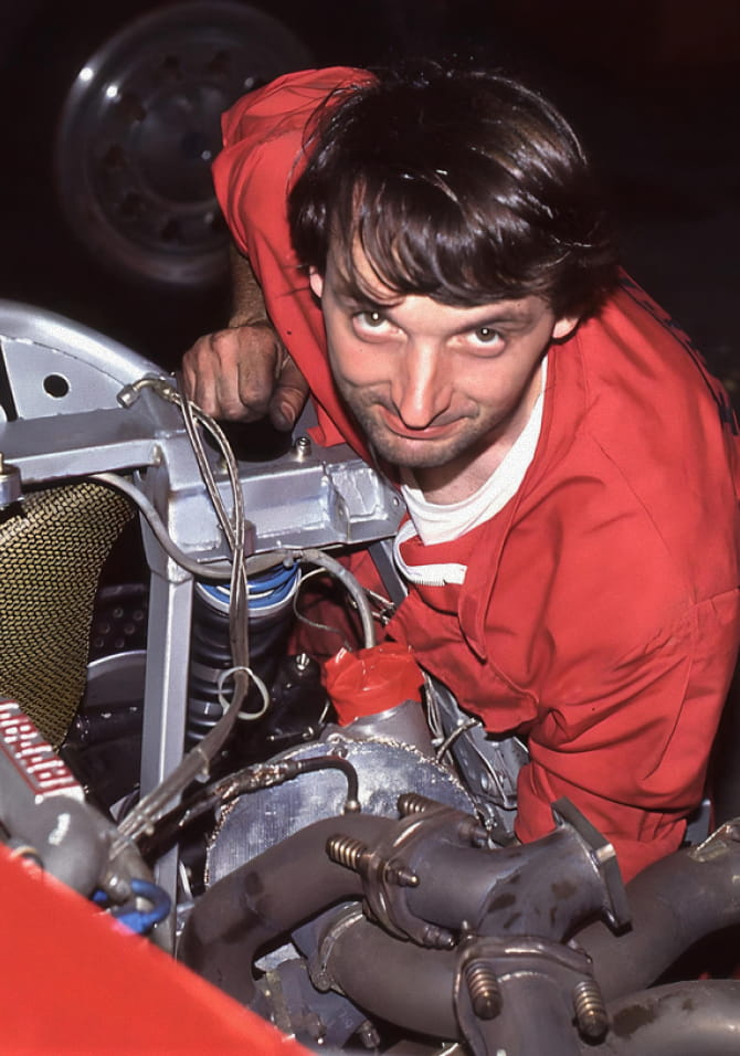 Ritratto di Francesco Calzavara in tuta rossa mentre lavora nel vano motore della Ferrari F40